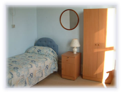 Picture of a bed, wardrobe and bed side table in one of the rooms